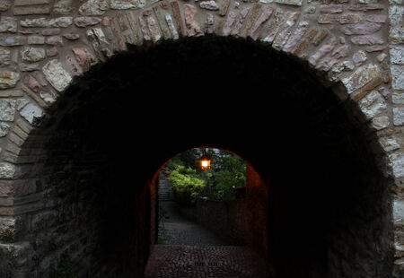 An Arch in Assisi with a lighted lamp.の写真素材