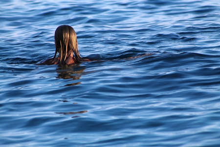 A Blonde woman swimming in the sea.の写真素材