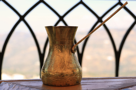 A Lebanese coffee pot made of brass in a traditional setting.の写真素材