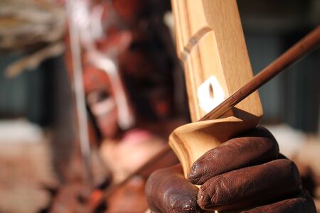 Man in costume shooting a wooden arrow.の写真素材