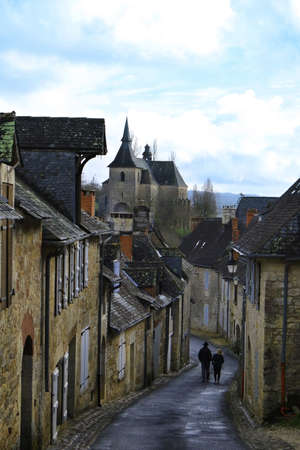 A couple walking in the Franch village of Turenne.