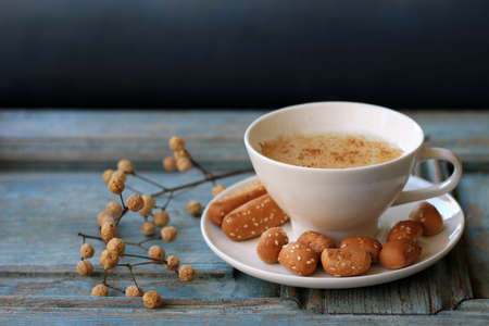 A cup of warm sahlab on a rustic wooden background.