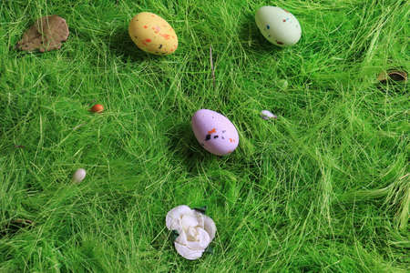 Pastel colored Easter chocolate eggs on green grass.の写真素材