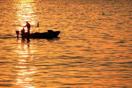Fishermen in their boat fishing during sunset in the Mediterranean sea.の写真素材