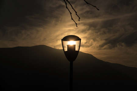 The sun during sunset trapped inside a street lamp.の写真素材