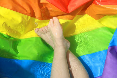 Toddlerâs feet in a rainbow colored pool splashing.の写真素材