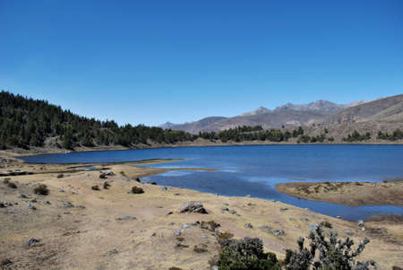Blue lagoon at the foot of the mountains and cypress forestの写真素材