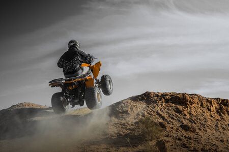 Man on quad in adventure at desert as extrem sport