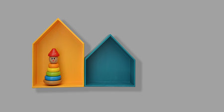 Stylish house shaped shelves with toys on gray wall. Baby and toddler room interior design, copy spaceの写真素材