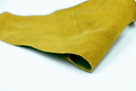 Genuine leather piece isolated on white background. Light green genuine leather roll. Real leather surface. Hobby and craft material. Manufacture, background textured and wallpaperの写真素材