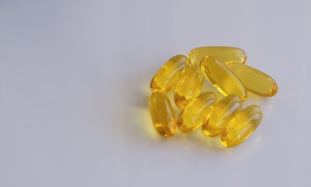 Fish oil omega 3 gel capsules on white background with copy space.