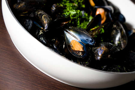 A pan of boiled mussels with parsley on top a mediterranean seafood dish