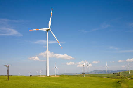 A wind farm with horizontal-axis rotors producing clean ecological green wind-powered energy through...