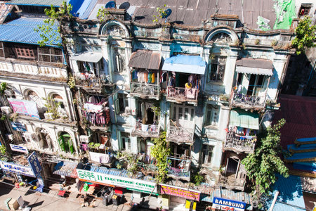 Yangon, Myanmar - 2017, January 7 : A historic colonial residential building in downtown Yangon seen from above with balconies and shops in the street below, Burmaのeditorial素材