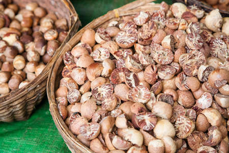 Some baskets filled with areca nuts or betel nuts on sale on a street market in central Myanmarの写真素材