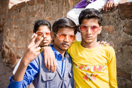 Jodhpur, India - 2015, January 4 : Three fashionable trendy kids with cool sunglasses in a street in...