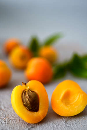 Apricots in a Vintage Bowl with Cinnamon Sticks and Leaves on a Gray Concrete Backgroundの写真素材