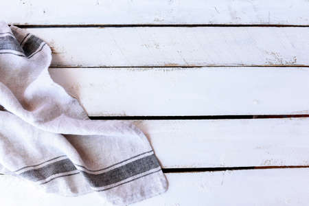 White Striped Kitchen Towel Linen on A White Wooden Background. Background with Cloth For Visuals