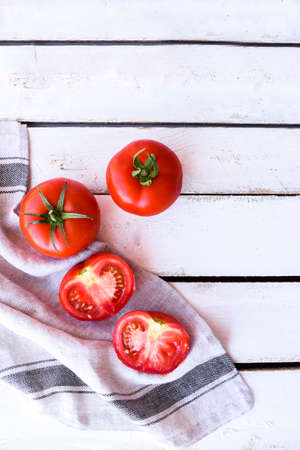 White Wooden Background with Striped Linen Cloth and Sliced Tomato. For Visualsの写真素材