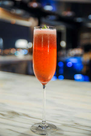 Cosmopolitan Cocktail in Champaign Glass With Blueberry on a White Marble Bar Counter