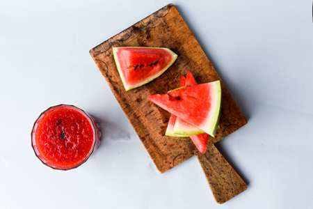 Watermelon Slice on a Wooden Cutting Board with Watermelon Juice on a Gray Backgroundの写真素材