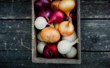 colored onion in a box on wood background.Top viewの写真素材