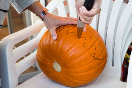 Close up of making of jack-o-lantern from a big pumpkinの写真素材