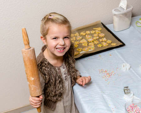 Little girl make cookies at the advent time  Funny child with with flour on the faceの写真素材