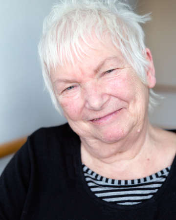 Portrait of happy older senior female with short white hairの写真素材
