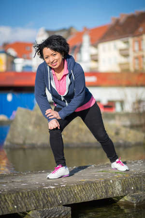 Healthy latina woman exercising in the city while joggingの写真素材