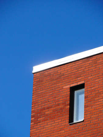                         Red wall and window on blue sky background       の写真素材