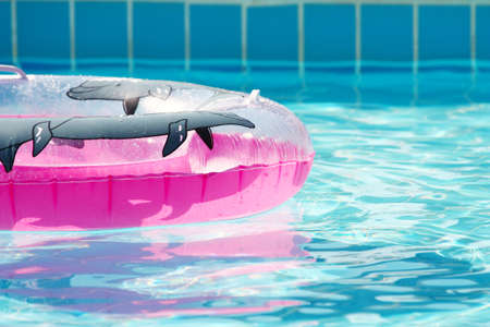 Pink inflatable round tube in swimming poolの写真素材