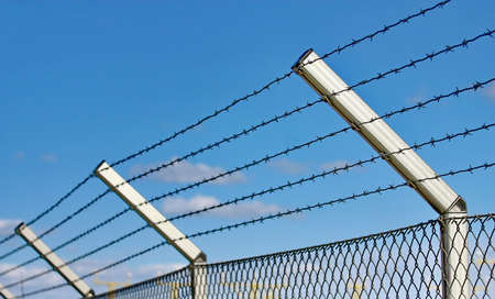 razor wire fence on the blue sky