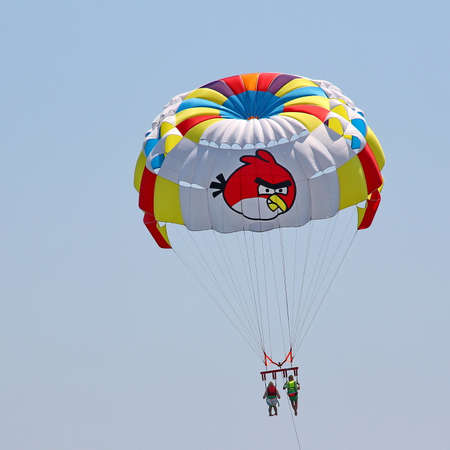 KEMER, TURKEY - AUGUST 14, 2015: Parasailing in a blue sky near sea beach. Parasailing is a popular recreational activity among tourists in Turkey.のeditorial素材