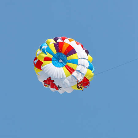 KEMER, TURKEY - AUGUST 14, 2015: Parasailing in a blue sky near sea beach. Parasailing is a popular recreational activity among tourists in Turkey.のeditorial素材