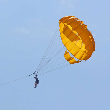 KEMER, TURKEY - AUGUST 14, 2015: Parasailing in a blue sky near sea beach. Parasailing is a popular recreational activity among tourists in Turkey.のeditorial素材