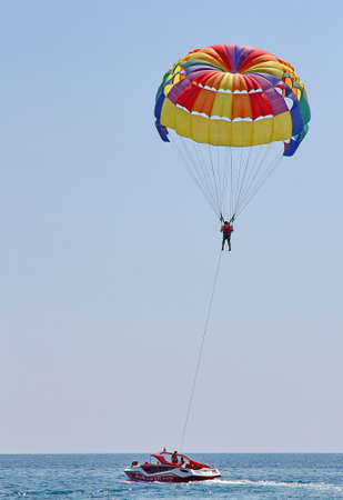 KEMER, TURKEY - AUGUST 18, 2015: Parasailing in a blue sky near sea beach. Parasailing is a popular recreational activity among tourists in Turkey.のeditorial素材