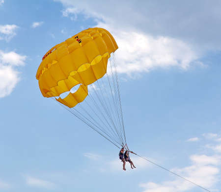 KEMER, TURKEY - AUGUST 16, 2015: Parasailing in a blue sky near sea beach. Parasailing is a popular recreational activity among tourists in Turkey.のeditorial素材