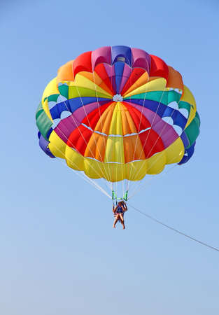 KEMER, TURKEY - AUGUST 18, 2015: Parasailing in a blue sky near sea beach. Parasailing is a popular recreational activity among tourists in Turkey.のeditorial素材