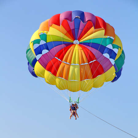 KEMER, TURKEY - AUGUST 18, 2015: Parasailing in a blue sky near sea beach. Parasailing is a popular recreational activity among tourists in Turkey.のeditorial素材