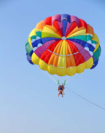 KEMER, TURKEY - AUGUST 18, 2015: Parasailing in a blue sky near sea beach. Parasailing is a popular recreational activity among tourists in Turkey.のeditorial素材