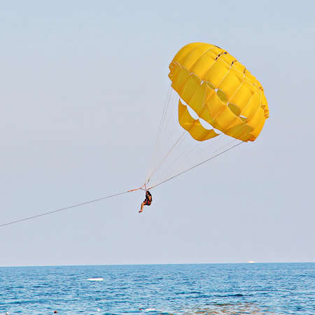 KEMER, TURKEY - AUGUST 14, 2015: Parasailing in a blue sky near sea beach. Parasailing is a popular recreational activity among tourists in Turkey. For editorial use only.のeditorial素材