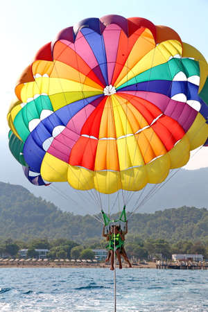 KEMER, TURKEY - AUGUST 18, 2015: Parasailing in a blue sky near sea beach. Parasailing is a popular recreational activity among tourists in Turkey. For editorial use only.のeditorial素材