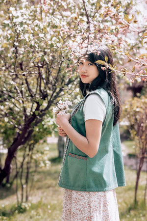 Young girl in ethnic traditional national Kazakh costume in spring garden