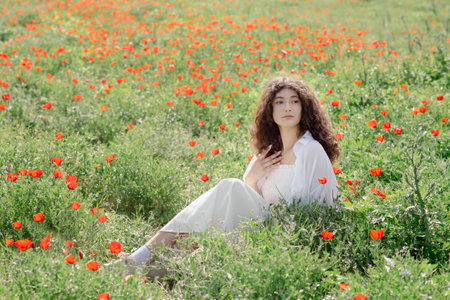 Model relaxing on poppy field, springtimeの写真素材