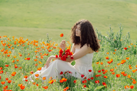 Model, beautiful woman relaxing on poppy field. Lifestyle.の写真素材