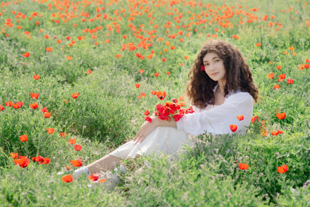 Model relaxing on poppy field, springtimeの写真素材