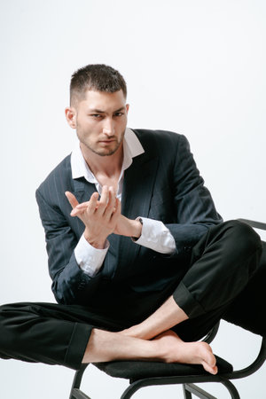 Handsome man, fashion model sits on chairの写真素材