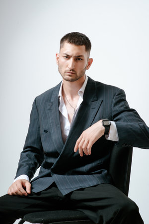 Portrait of handsome man, fashion model. Sits on chair.の写真素材