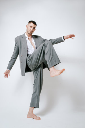 Fashion man model in gray suit, barefoot, shoot in studioの写真素材